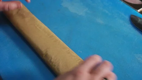 Chef rolling up white cod fish for baking in a Parchment Pape renvelope Stock Footage 204818933