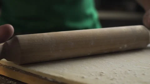 Chef rolls out the dough with a rolling pin on the kitchen table Video stock 143779473