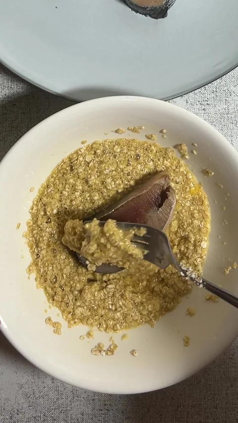 Chef rolls piece of fish in plate with batter, egg, oatmeal, flour before frying Stock Footage 278842866