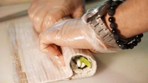 Chef rolls sushi with avocado and cream cheese using a bamboo mat 스톡 동영상 346715259
