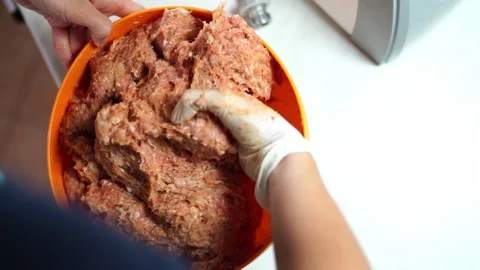 Chef in a rubber glove stirs minced meat in a large bowl 스톡 동영상 287956385