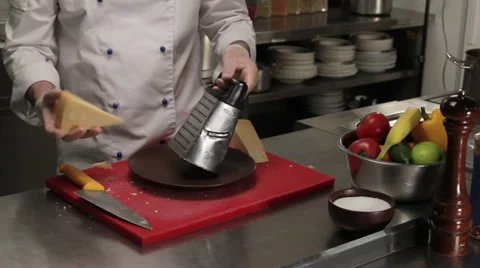Chef rubbing cheese on a grater, medium shot 스톡 동영상 66074996
