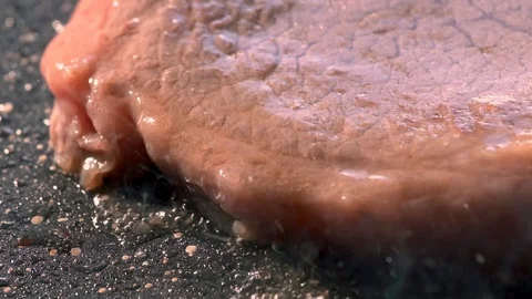 Chef salt grilled meat at stone cutting board. Closeup man hands salting steak Stock Footage 115777370