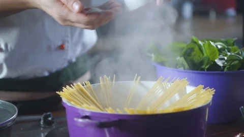 Chef salt pan of pasta spaghetti standing on stove at kitchen restaurant. Vidéo 124709504