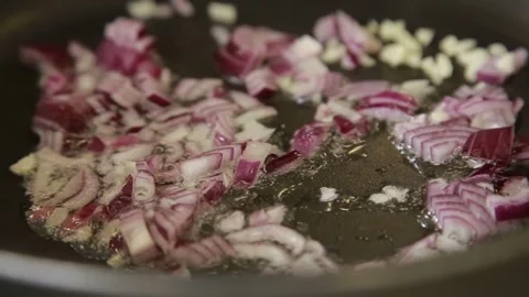 A chef sauteing finely diced red onion in a frying pan Stock Footage 340553864