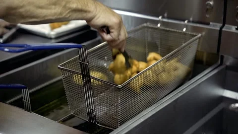 Chef scooping done Zepoli from deep fryer Basket Williamsburg Brooklyn Stock Footage 252330695