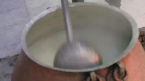 Chef scoops cooked rice from large ancient cauldron with long-handled ladle Vidéo 332894555