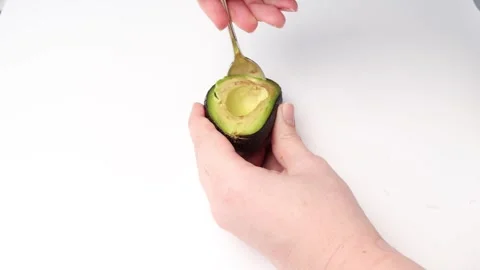 A chef scoops out avocado pulp from the peel, preparing healthy food. Stock Footage 282783573