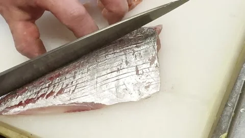 Chef scoring the silver skin of a fresh horse mackerel fillet Stock Footage 339382097