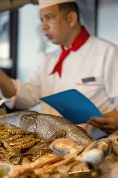 Chef in seafood restaurant offering various seafood Stock Photos