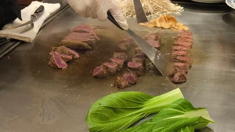 The chef sears Kobe beef on a hot grill, preparing it fresh for the omakase.. Stock Footage 323202414
