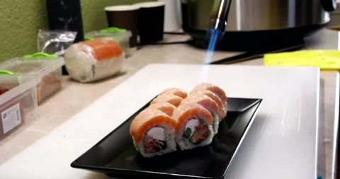 Chef sears sushi on a black plate Stock Footage 285435668