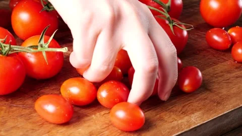 Chef selecting cherry tomatoes on wooden cutting board Stock Footage 305808545