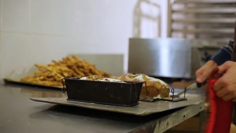 Chef separates the bread from the bakeware with a knife Vidéo 106463685