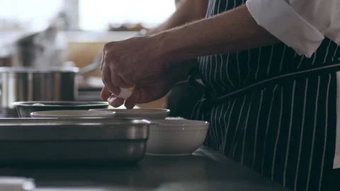 Chef separating eggs in a bowl in interior kitchen with soft day lighting. Close Stock Footage 199457428