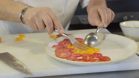 Chef serves chopped tomatoes on a plate Stock Footage 230974428