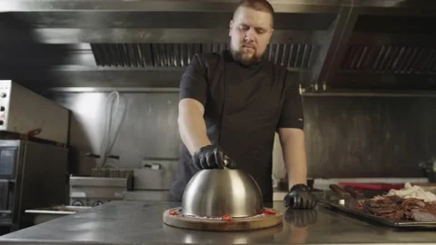 A chef serves a dish in a restaurant kitchen. Stock Footage 236900573