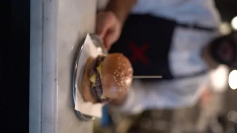 The chef serves the hamburger he prepared - Vertical Shoot - 4k 100 fps Video stock 196195068