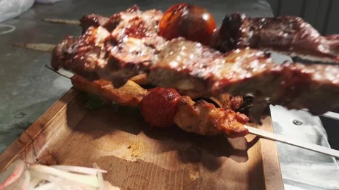 The chef serves kebabs with chicken, cape and liver on a wooden board with Stock Footage 255934226