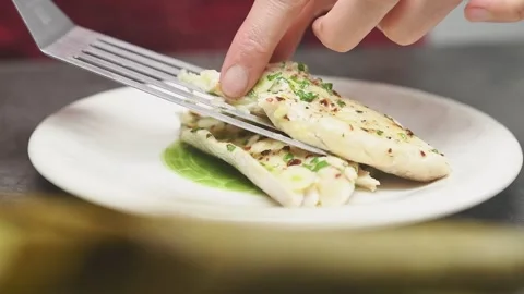 Chef serves a piece baked fish on a plate. Stock Footage 161015192