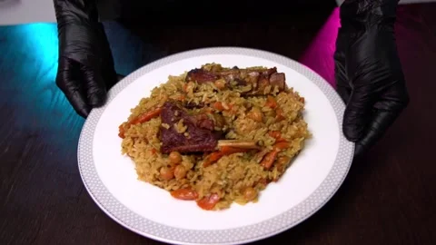 The chef serves pilaf on the table. Hot pilaf serving on a plate Stock Footage 171727728