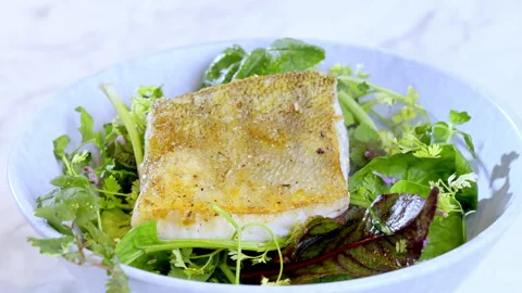 The chef serves a portion with salad and white fish. Fried zander and salad. Stock Footage 274070148