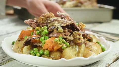 The chef serves roasted lamb shoulder with vegetables. Stock Footage 195531239