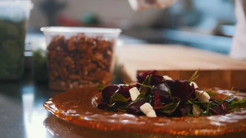 Chef serves the salad by placing the components on a plate and laying the nuts Stock Footage 86067194