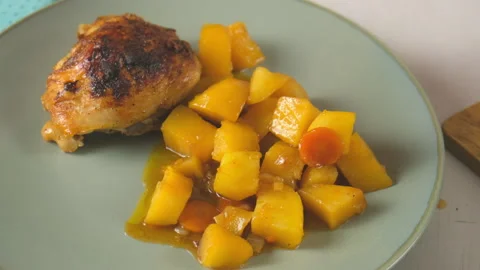 Chef serving arranging potatoes and carrot stew next to chicken thigh on plate. Stock Footage 317175026
