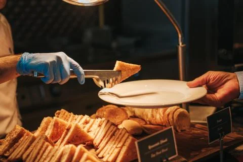 Chef is serving canapes toasted bread with cheese and tomato in a restaurant. Stock Photos
