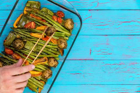 Chef serving a dish of fresh roast vegetables Stock Photos