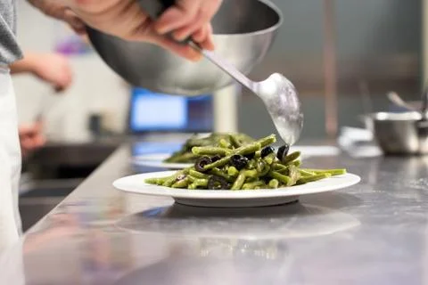 Chef serving fresh green bean salad from a bowl Stock Photos