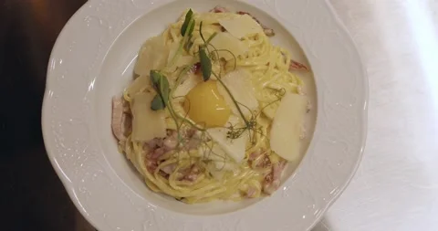 Chef serving freshly cooked pasta carbonara on plate Stock Footage 221634295