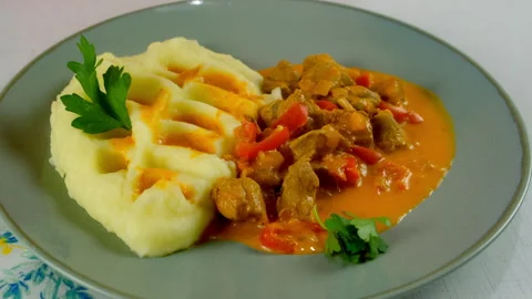 Chef serving goulash and mashed potatoes with herbs on plate on kitchen at home. Stock Footage 312403281