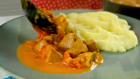 Chef serving goulash with mashed potatoes on plate on kitchen at home. Stock-Footage 312403021