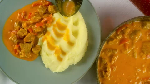 Chef serving goulash with mashed potatoes on plate on kitchen at home. Stock Footage 312403096