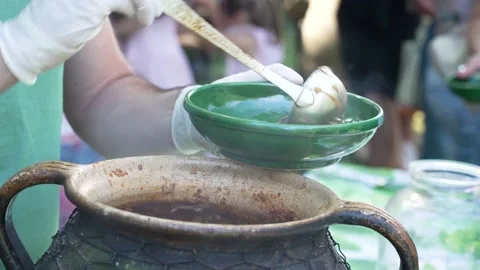 Chef serving hot traditional goulash from a cauldron at a food festival Stock Footage 346183221
