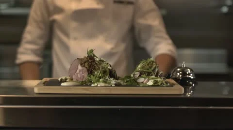 Chef serving meal at pass(rings bell) waitress collecting Stock Footage 20432587