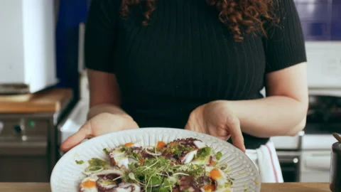 Chef serving octopus carpaccio dish on a cutting board. Medium close on a RED ca Stock Footage 199462401