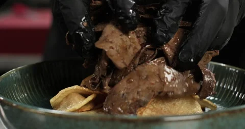 Chef serving oriental dish, puts roasted liver on potato slices. Close-up Stock Footage 294533894