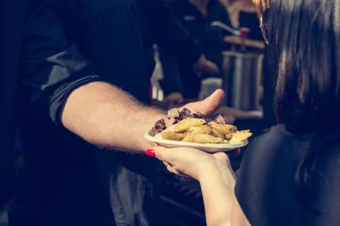 Chef serving potatoe dish to customer at outdoor stand Stock Photos