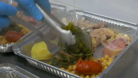 Chef serving some stew on foil containers to take away Stock Footage 149755680