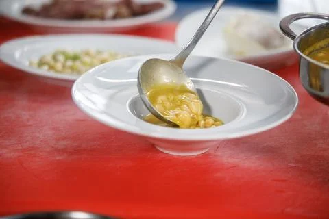 Chef is serving some white beans in a plate Stock Photos