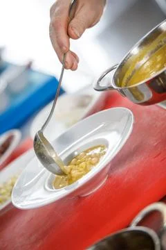 Chef is serving some white beans in a plate Stock Photos