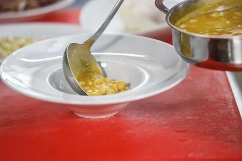 Chef is serving some white beans in a plate Stock Photos