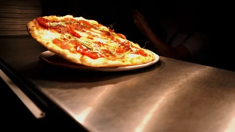 Chef serving steaming pizza on plate Stock Footage 107164976