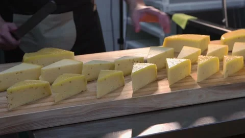 A chef serving triangle pieces of cheese on the desk Stock Footage 160079971