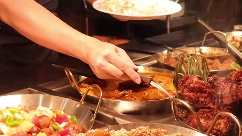 Chef Serving Various Asian Dishes from a Buffet Counter 스톡 동영상 325691820