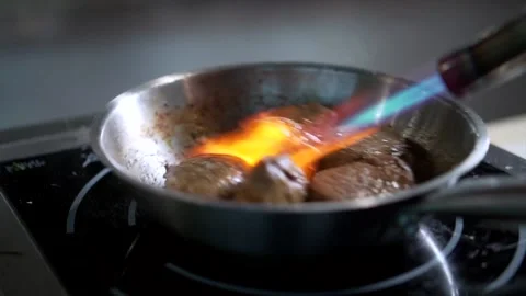 Chef sets fire to pieces of meat with a burner Stock Footage 160400541