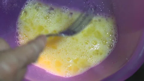 The chef shakes a fork in a bowl of egg mass for pancakes Stock-Footage 85951745
